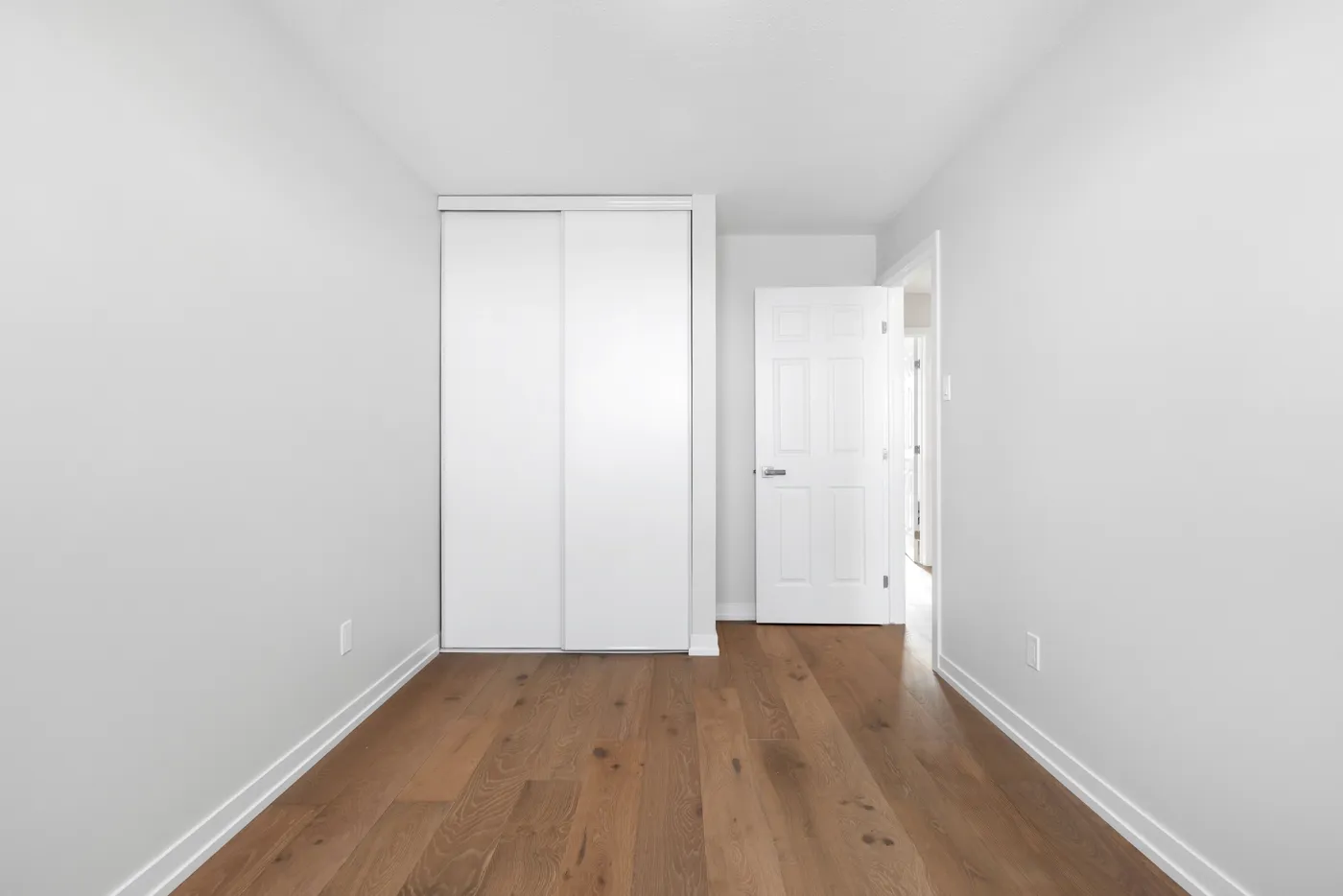 Leeres Schlafzimmer mit Parkett und Einbauschrank vor virtuellem Staging